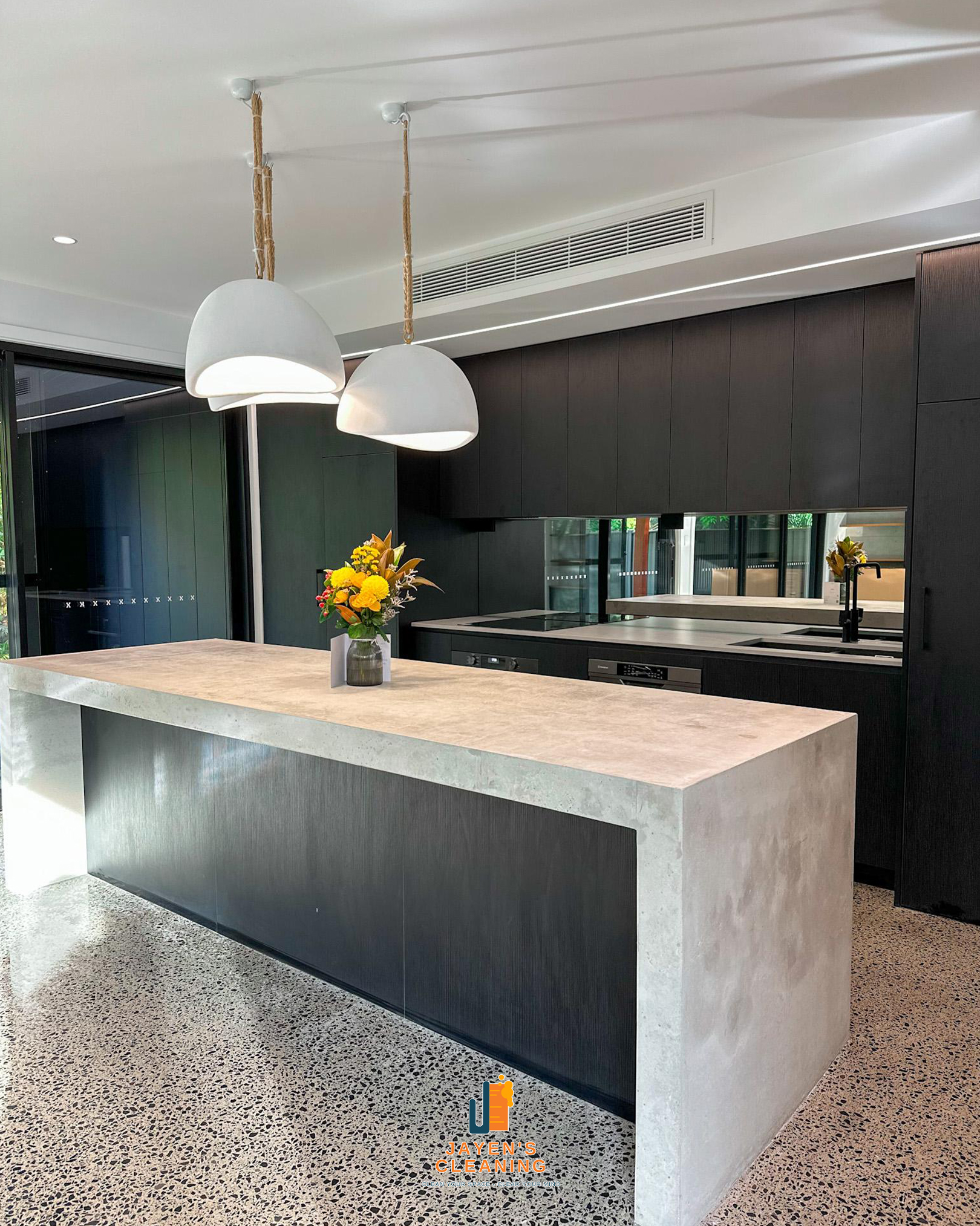 A kitchen cleaned by Jayen’s, with a stone island and warm natural light